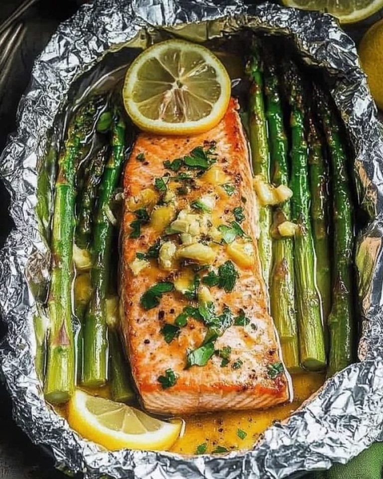 Pieczony łosoś w folii ze szparagami i masłem, sosem czosnkowo-cytrynowym