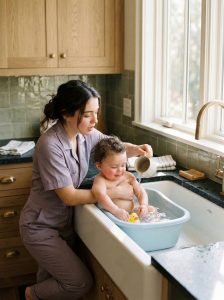 Miliarder zwolnił pokojówkę za to, że kąpała jego dziecko w kuchennym zlewie… kilka minut później jego syn przestał oddychać Marcus Whitaker nie był człowiekiem, który tolerował błędy. W wieku trzydziestu siedmiu lat podpisem zamykał kontrakty warte miliardy, zarządzał firmami na różnych kontynentach i wymagał absolutnego porządku w każdej dziedzinie życia. Od śmierci żony to właśnie kontrola była jedynym, co utrzymywało jego świat w całości. Z jednym wyjątkiem. Jego ośmiomiesięczny syn, Zion. Chłopiec był wszystkim, co Marcusowi zostało. Tamtego popołudnia wrócił do swojej rezydencji kilka godzin wcześniej, niż planowano. Nikogo o tym nie uprzedził. Ani ochrony. Ani personelu. Nawet Margaret — surowej niani, która prowadziła dom niczym wojskową operację. Chciał zobaczyć prawdę. Nie wersję, którą dla niego odgrywano. Idąc przez ciche marmurowe korytarze, poczuł, że coś jest nie tak. Zbyt cicho. Zbyt chaotycznie. W końcu dotarł do kuchni. I zamarł. Światło słoneczne wpadało przez wysokie okna, oświetlając scenę, która natychmiast ścisnęła mu serce. Zion był w zlewie. Siedział w małej plastikowej wanience wypełnionej ciepłą wodą. A osoba, która go kąpała… nie była nianią. To była Emily. Nowa sprzątaczka. Stała tam z podwiniętymi rękawami, włosami związanymi w luźny kok, delikatnie polewając małe rączki dziecka wodą i uśmiechając się łagodnie, nucąc cicho, jakby to była najnaturalniejsza rzecz na świecie. Marcus poczuł, jak zalewa go gniew. — Co ty, do diabła, wyprawiasz? — jego głos przeciął pomieszczenie jak szkło. Emily drgnęła i odwróciła się gwałtownie. — Proszę pana… mogę wyjaśnić— — Kąpiesz mojego syna w kuchennym zlewie? — warknął, robiąc krok do przodu. — Gdzie jest Margaret? — Wyszła na chwilę, a Zion płakał, więc— — Więc uznałaś, że możesz ją zastąpić? — przerwał chłodno. — Jesteś sprzątaczką, nie opiekunką. Zion zachichotał, chlapiąc wodą, zupełnie nieświadomy napięcia wypełniającego pomieszczenie. Ale Marcus już na niego nie patrzył. Patrzył na Emily. Wściekły. — Odejdź od niego — rozkazał. Emily zawahała się. — Proszę pana, woda jest ciepła, wszystko sprawdziłam, on jest bezpieczny— — Powiedziałem: odsuń się. Jej ręce lekko zadrżały, gdy zrobiła krok w tył. Marcus wyjął Ziona z wanienki i owinął go ręcznikiem, zaciskając szczękę. — Jesteś zwolniona — powiedział bez emocji. Twarz Emily pobladła. — Proszę pana… on był niespokojny, ja tylko chciałam pomóc— — Nie płacę ci za podejmowanie decyzji — przerwał jej ostro. — Płacę ci za wykonywanie poleceń. W kuchni zapadła cisza. Emily przełknęła ślinę, skinęła głową i zdjęła rękawiczki. — Oczywiście, proszę pana — powiedziała cicho. I wyszła. Tak po prostu. Wszystko wydarzyło się mniej niż dziesięć minut później. Marcus siedział w salonie, trzymając Ziona przy ramieniu. Wciąż był rozdrażniony, wciąż odtwarzał w głowie to, co się wydarzyło. I wtedy to poczuł. Dziecko nagle znieruchomiało. Zbyt nieruchomo. Marcus odsunął się. Twarz Ziona się zmieniła. Jego usta… zaczynały sinieć. — Zion? — powiedział ostro Marcus. Brak reakcji. Klatka piersiowa dziecka ledwo się poruszała. — Zion! — jego głos się załamał. Panika uderzyła w niego z całą siłą. Rzucił się w stronę drzwi, wołając o pomoc, a jego serce biło tak mocno, że zagłuszało wszystko inne. — Dzwońcie po karetkę! Personel wybiegł. Telefony spadały na podłogę. Wybuchł chaos. Marcus przycisnął syna mocniej do siebie, a jego ręce drżały po raz pierwszy od wielu lat. — Oddychaj… proszę, oddychaj… W szpitalu wszystko działo się zbyt szybko. Lekarze natychmiast zabrali Ziona na oddział ratunkowy. Maszyny piszczały, polecenia padały jedno po drugim. Marcus stał na zewnątrz. Zastygły. Bezradny. Po raz pierwszy w życiu… kontrola nie miała żadnego znaczenia. Minuty ciągnęły się jak godziny. W końcu z sali wyszła lekarka. Jej twarz była poważna. — Panie Whitaker — powiedziała — pański syn jest już stabilny. Marcus wypuścił powietrze, niemal osuwając się z nóg. — Co się stało? — zapytał. Lekarka zawahała się przez moment. Potem spojrzała na niego uważnie. — Czy przed tym, jak przestał oddychać… był kąpany? Marcus zmarszczył brwi. — Tak. Dlaczego? Oczy lekarki lekko się zwęziły. — W takim razie powinien pan wiedzieć jedno… To, co powiedziała później, uświadomiło Marcusowi, że właśnie popełnił największy błąd w swoim życiu. Ciąg dalszy w pierwszym k0mentarzu👇👇👇 Voir moins